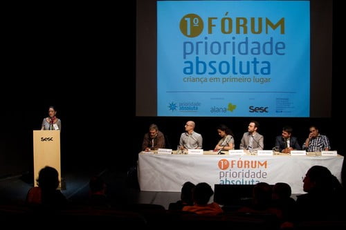 Foto mostra uma banca de especialista, em frente a um painel "1º Fórum Prioridade Absoluta"