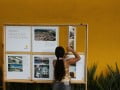 Foto mostra criança brincando com painel que conta um pouco da história do Espaço Alana