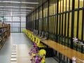 Foto da biblioteca do Espaço Alana mostra estantes com livros e mesas com computadores