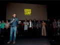 Foto mostra Marcos Nisti e equipe do Alana no palco. Ao fundo, telão escrito "Videocamp"