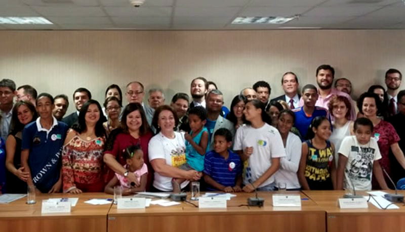 Pessoas posando para uma foto, atrás de uma bancada.