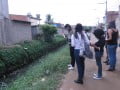 Foto de adolescentes olhando rio poluído