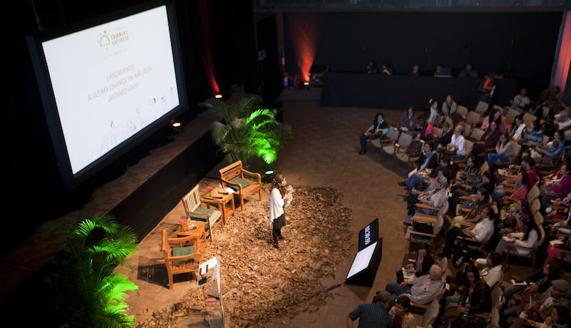 Foto do seminário Criança e Natureza mostra, de ângulo superior, auditório e palestrante.