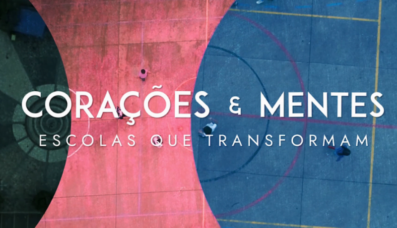 Fundo de três cores verde, rosa e azul, com letreiro escrito "Corações e Mentes: Escolas que Transformam".