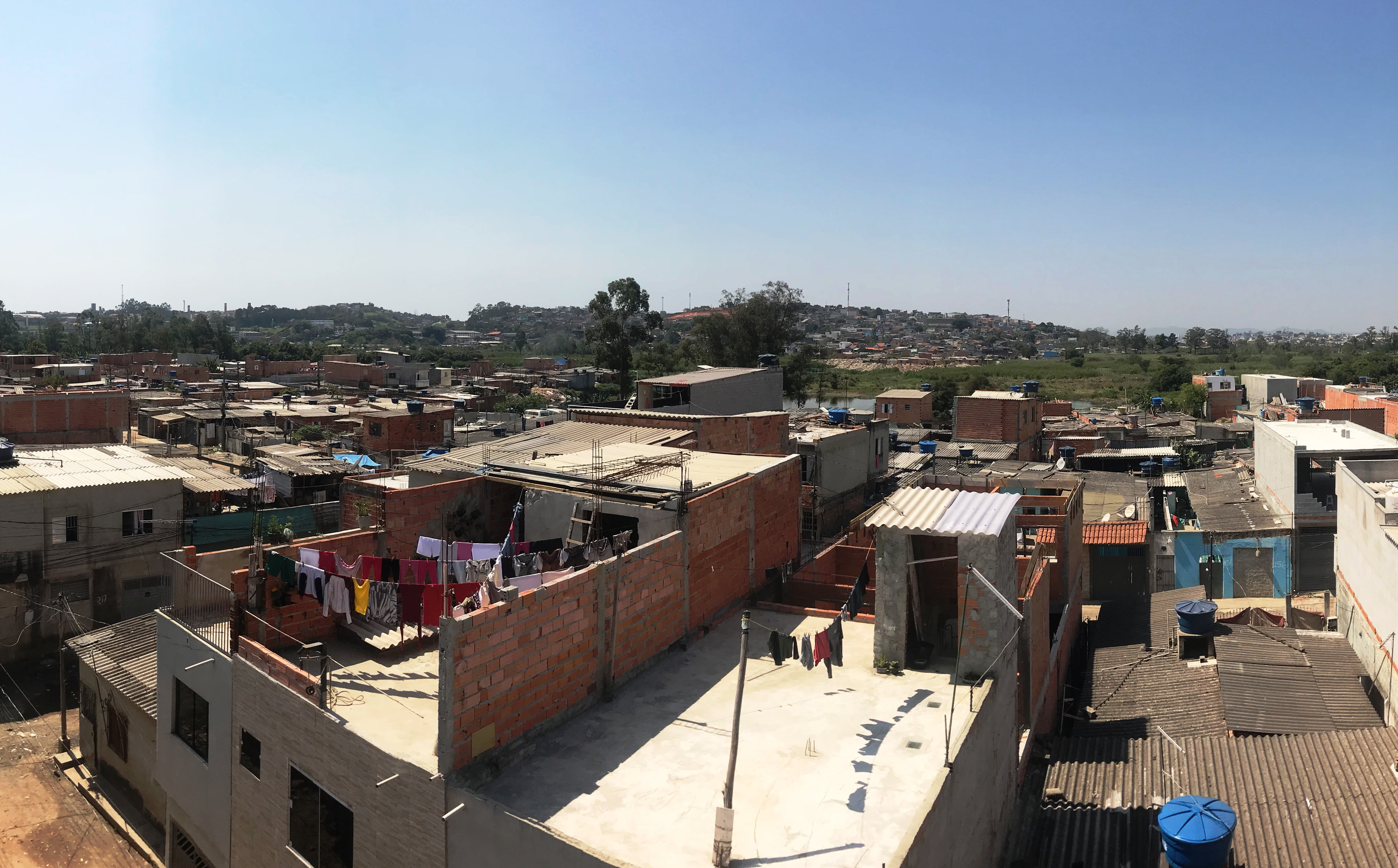 Paisagem com a região do Jardim Pantanal visto de cima. Na imagem há várias casas e ao fundo há o céu azul