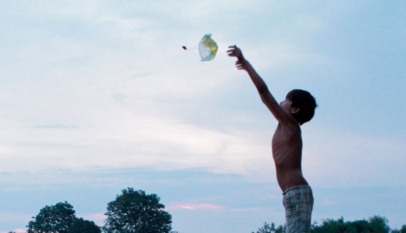 A foto que ilustra a nota pelo incêndio na escola Xukurank mostra criança indígena brincando com balão